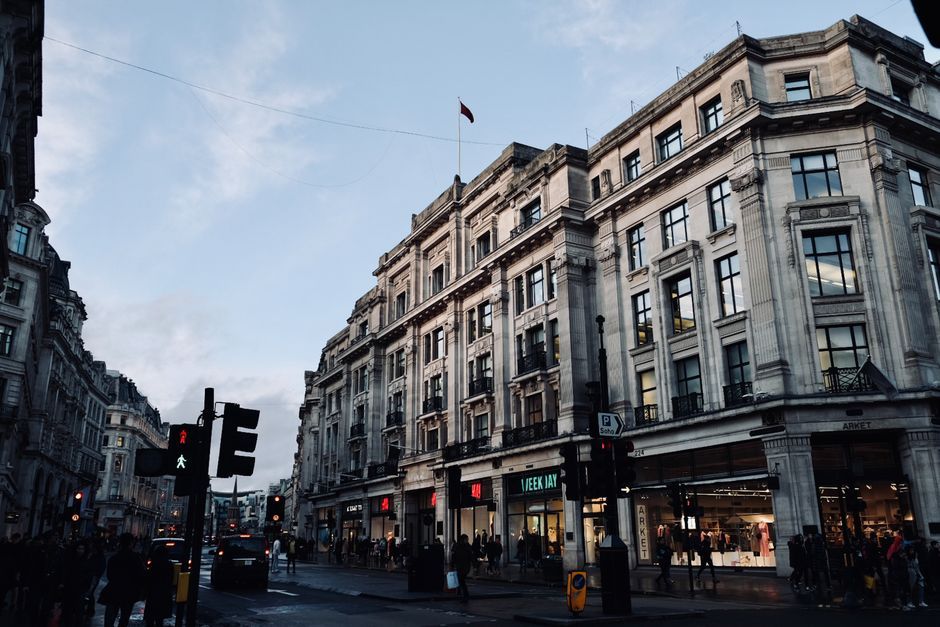 A British high street with shops and traffic lights on a bright day.